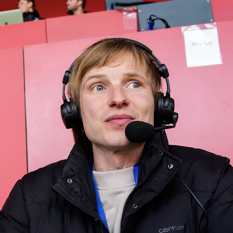 Commentator met headset op de perstribune
